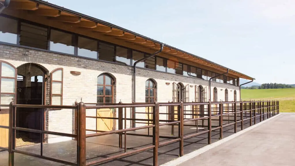 Pferdestall mit Klinkerfassade von aussen mit Paddocks