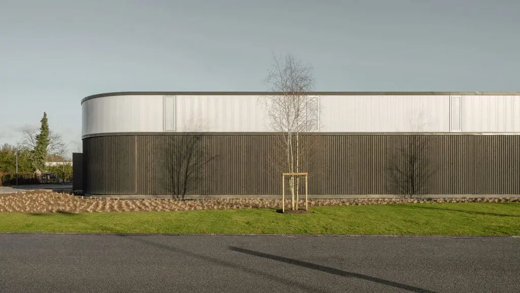 Blick von aussen auf modernes Gebaeude mit dunkler Holzfassade
