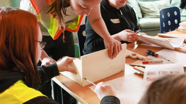 Auszubildende unterstuetzt die Maedchen beim Bau ihres Schmuckstaenders am Girls' Day 2023