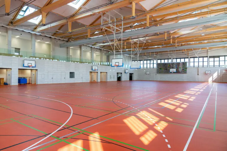 Sporthalle in Holzbauweise, erste 8-Fach Sporthalle Europas von Schlosser planprojekt und SCHLOSSER Holzbau. Hier zu sehen, die andere Halle im gleichen Gebäude mit rotem Sporthallenboden.