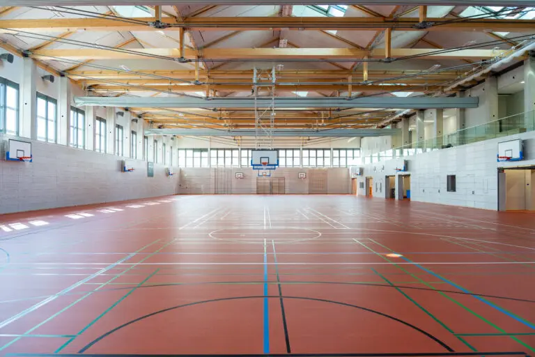 Sporthalle in Holzbauweise, erste 8-Fach Sporthalle Europas von Schlosser planprojekt und SCHLOSSER Holzbau. Hier zu sehen, die andere Halle im gleichen Gebäude mit rotem Sporthallenboden in der gesamten Flucht.