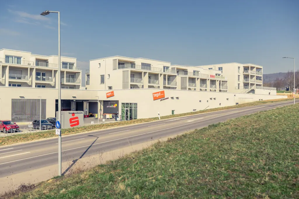 Projekt "LIAS", ein Holzhybridbau bei dem unten ein Supermarkt und oben Wohnungen gebaut wurden .Ansicht Supermarkt Eingang.