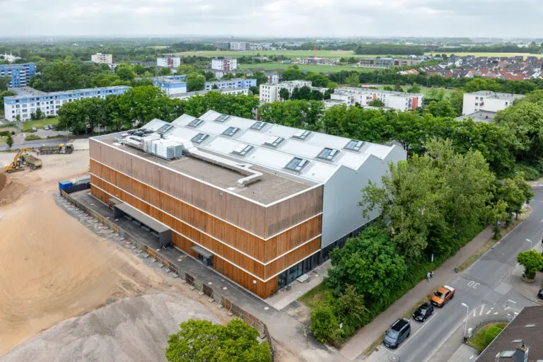 Sporthalle in Holzbauweise, erste 8-Fach Sporthalle Europas von Schlosser planprojekt und SCHLOSSER Holzbau. Hier zu sehen, die Halle in der Außenansicht per Drohnenflug kurz nach Fertigstellung.