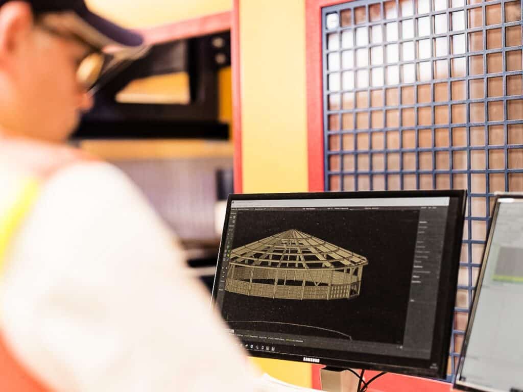 SCHLOSSER -Mitarbeiter in der Produktion blickt auf den Bildschirm seines PCs, wo eine Holzkonstruktionszeichnung zu sehen ist