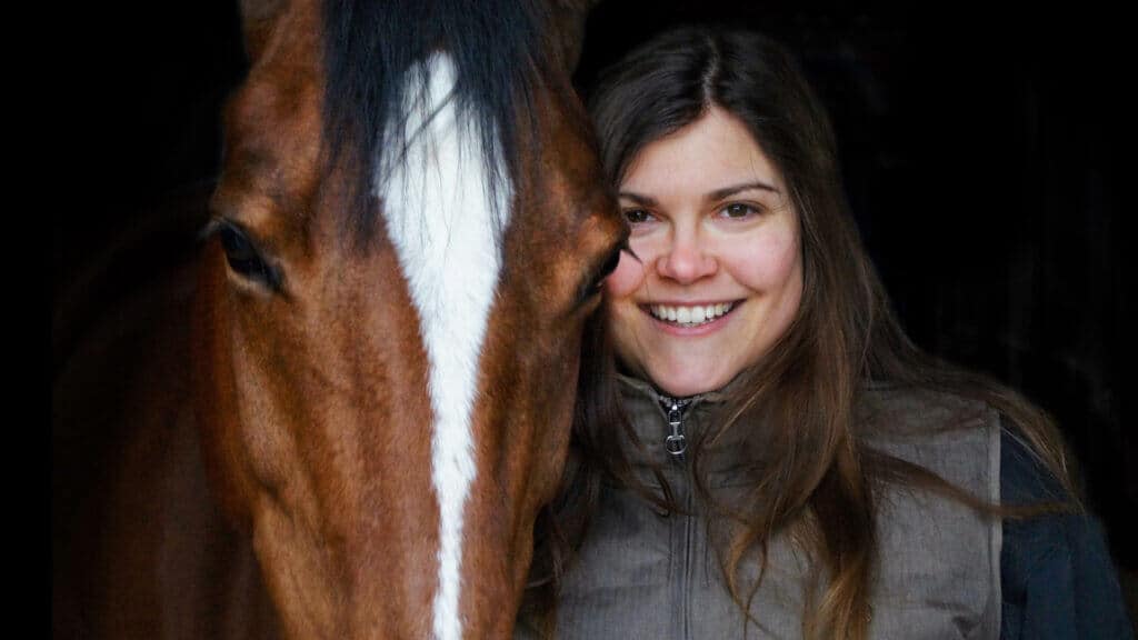 Portraitaufnahme eines Pferdes mit Frau daneben