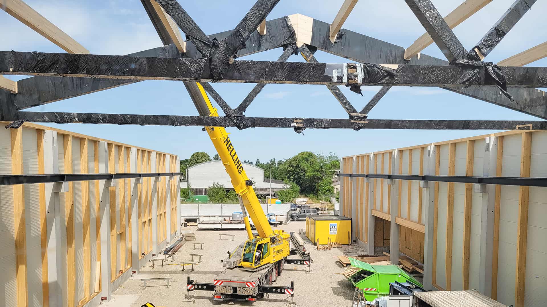 Die ersten Binder werden mit Hilfe von Kränen auf der Baustelle in München montiert