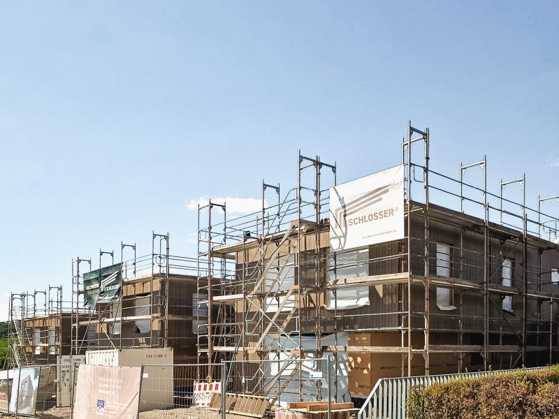 Baustelle dreier baugleiche Häuser während der Bauphase in Holzbauweise